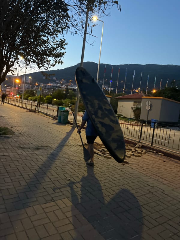 Person carries paddleboard through Alanya streets