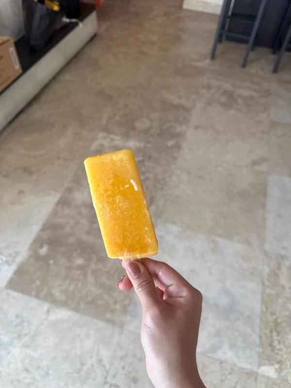 Person enjoys yellow popsicle indoors in Acapulco