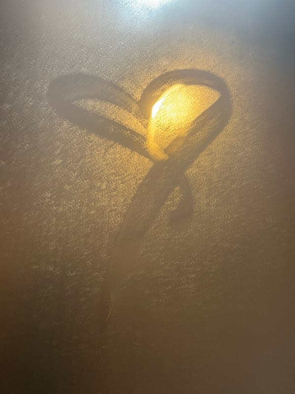 Heart in foggy window, empty street captured at dusk