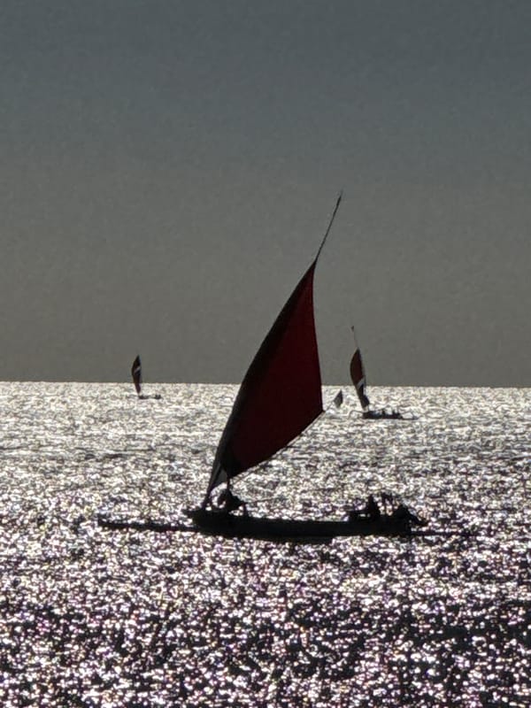 Red-sailed boat spotted on sparkling waters near Abang, Indonesia