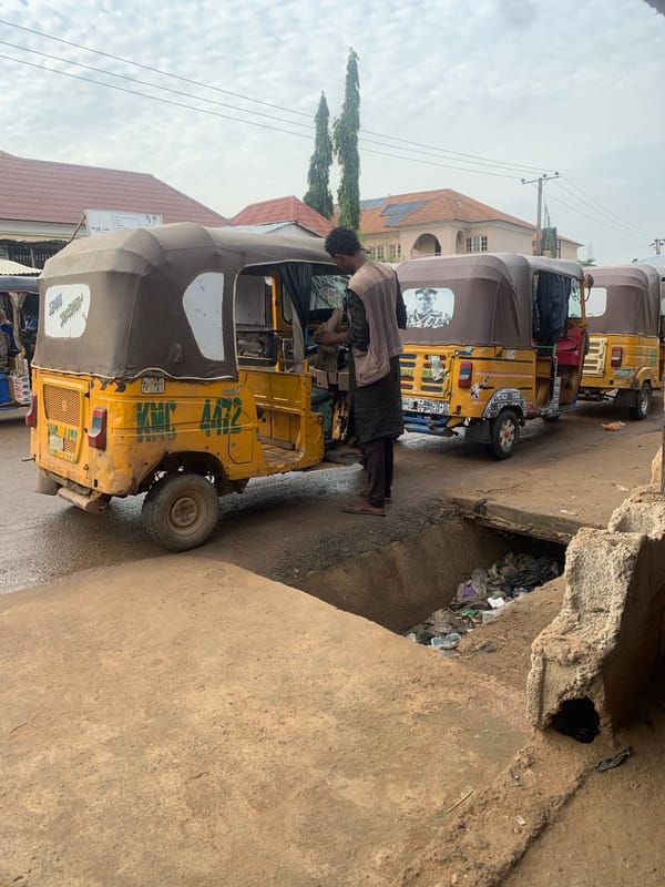 Wet morning street life along a busy Abuja road