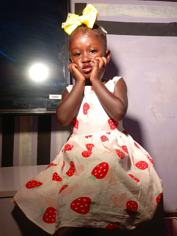 Young girl in strawberry dress photographed in Akwanga photoshoot