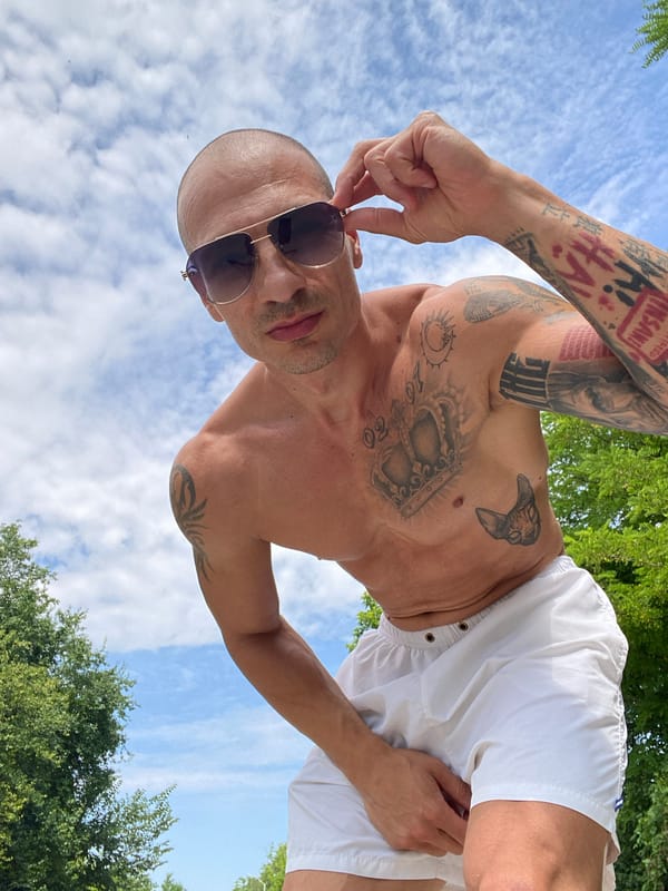 Tattooed, shirtless and relaxed at a Pleven outdoor spot