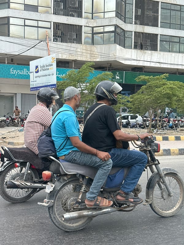 Motorcycles moving through a Karachi city street
