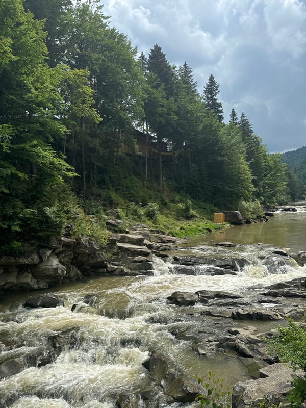 Prut River rapids and flag-lined bridge in Yaremche, Ukraine