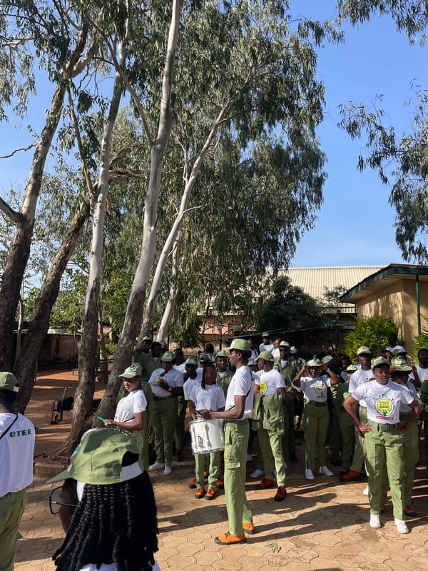 Youth corps members gather with instruments in Jos courtyard