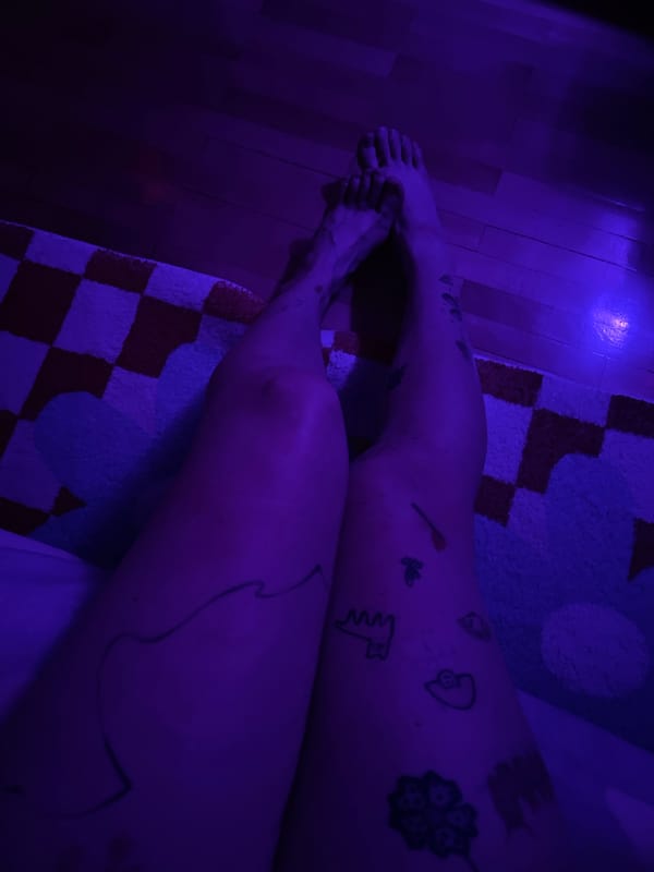 Person relaxes in colorfully lit Belgrade bedroom with artwork