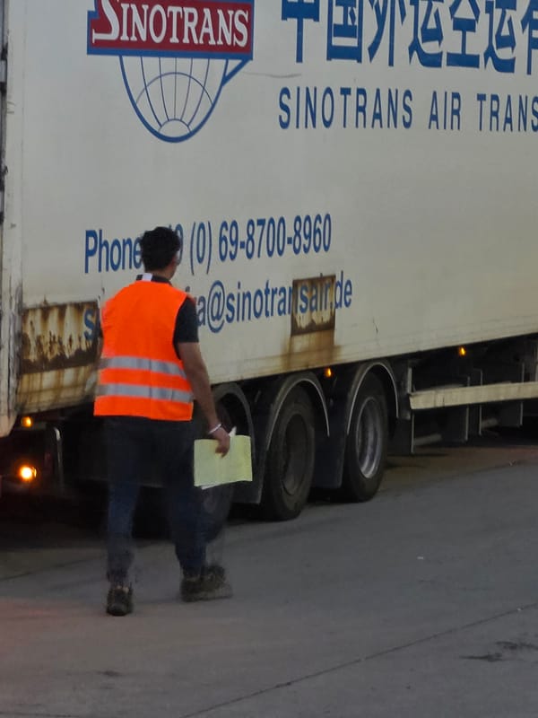 Frankfurt truck yard, freight workers and air cargo trailers in motion