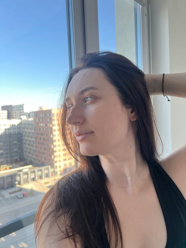 Woman gazes at Tyumen cityscape through window
