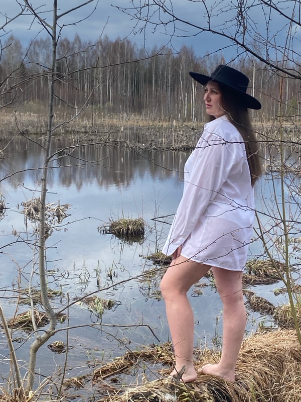 Woman stands barefoot in shallow water near Markovo, Russia