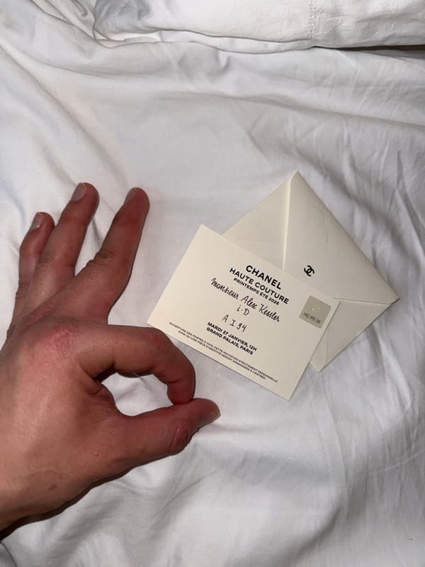 Person makes OK hand gesture on white fabric in Paris