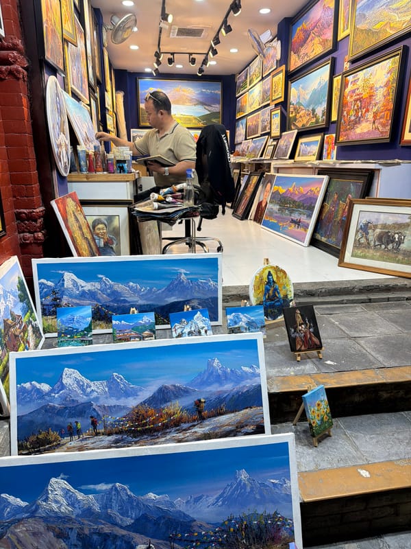 Man browses paintings at art shop in Pokhara