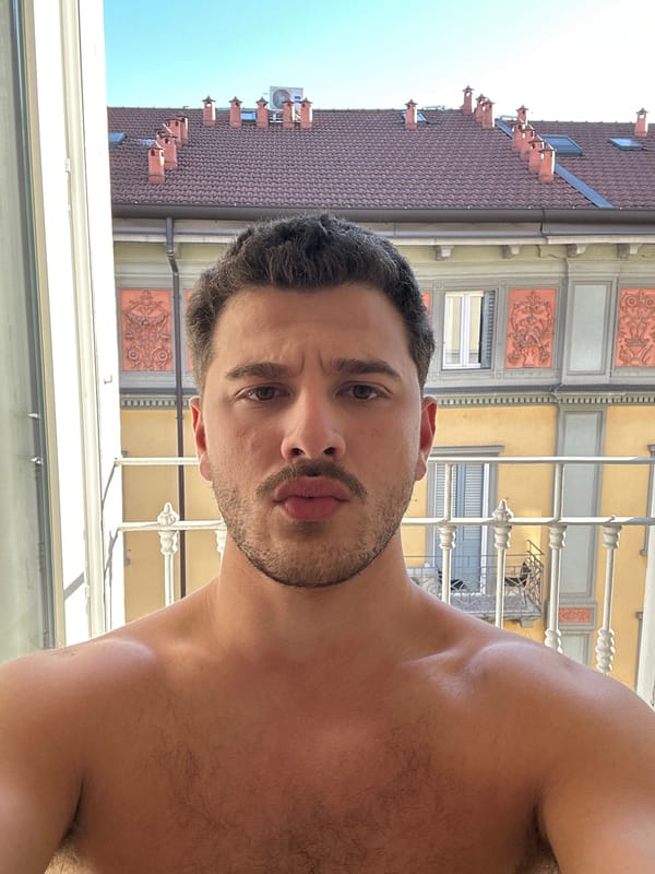 Man takes shirtless selfie by window in Milan