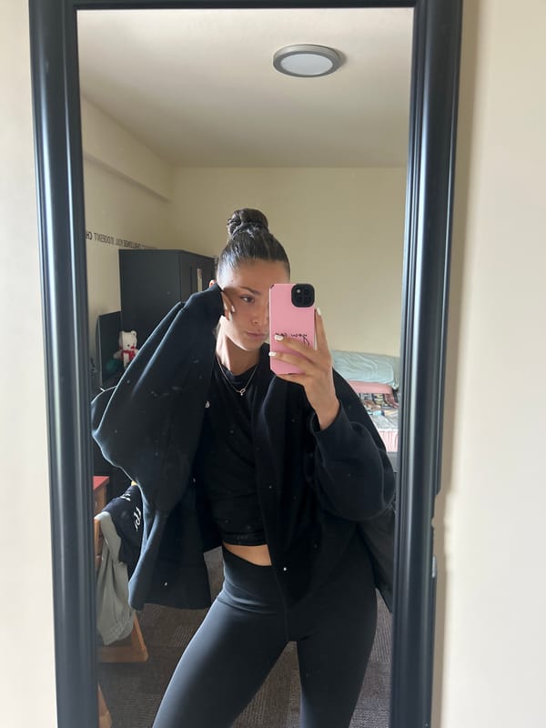 Woman takes mirror selfie in athletic wear at university