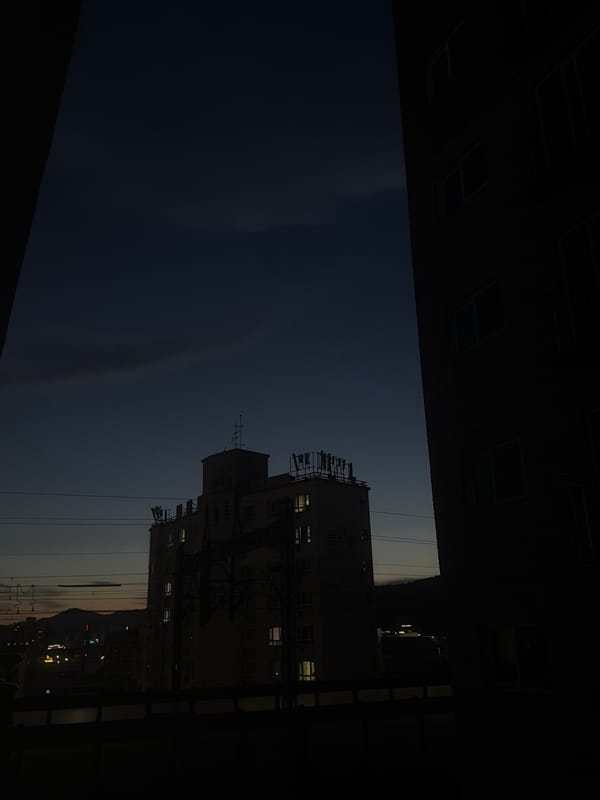 Dusk settles over residential Dongducheon, a lit window draws the eye