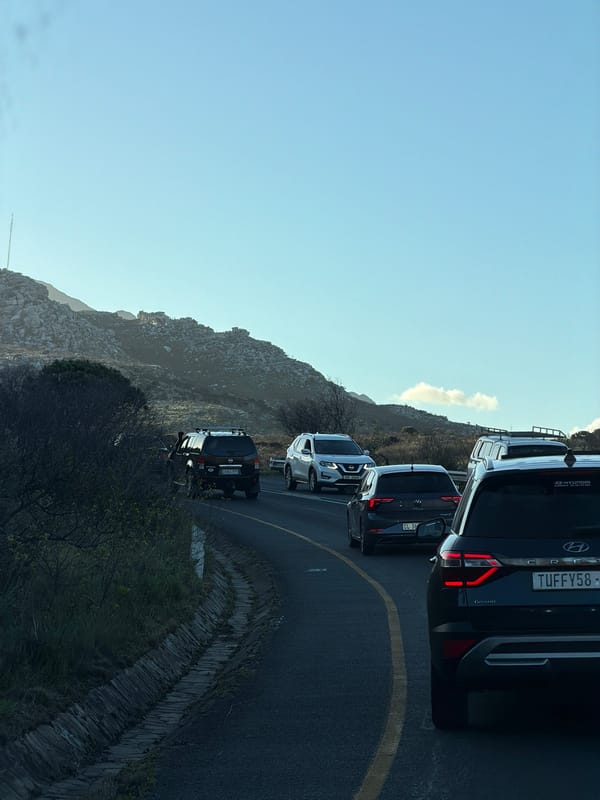 Vehicles queue along mountain road in Noordhoek