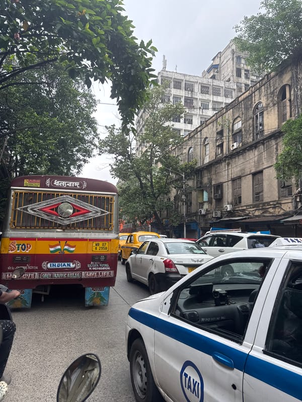 Kolkata street life captured with colorful vehicles, selfie-taking commuter