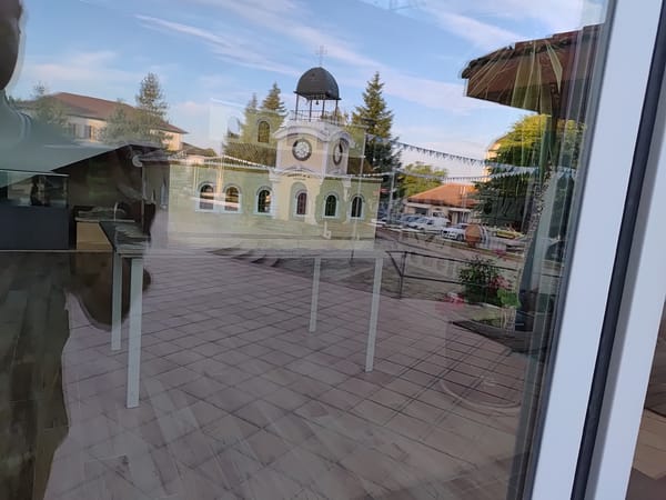 Church reflections, blooming roses, and a festive fountain square