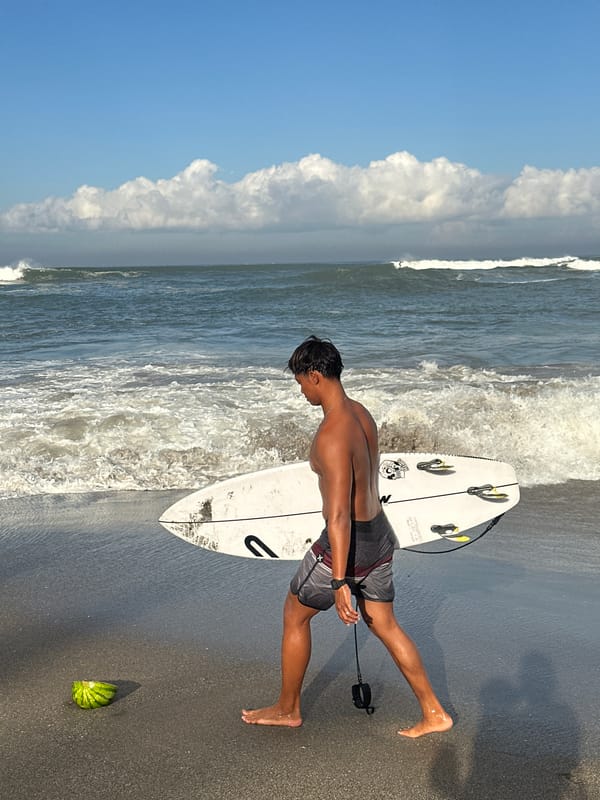 Surfers and beachgoers fill North Kuta's shoreline on a busy morning.