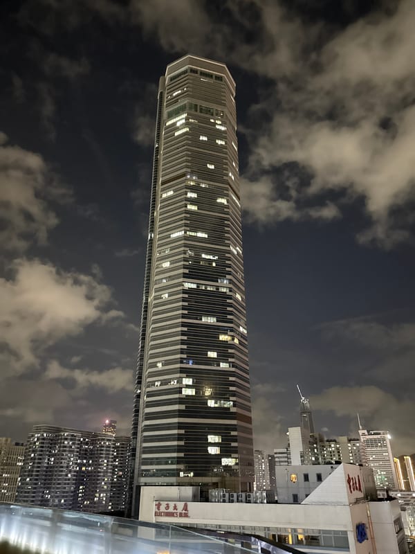 Futian District skyline lit up at night, close and wide.