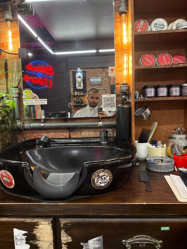Customer takes selfie during haircut at Đà Nẵng barbershop