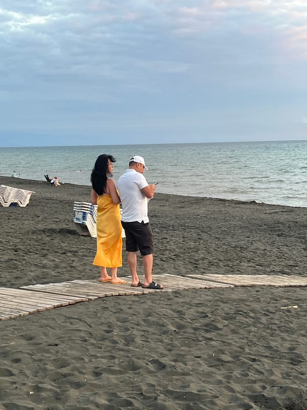Sunset stroll along Ureki's black sand beach by bicycle