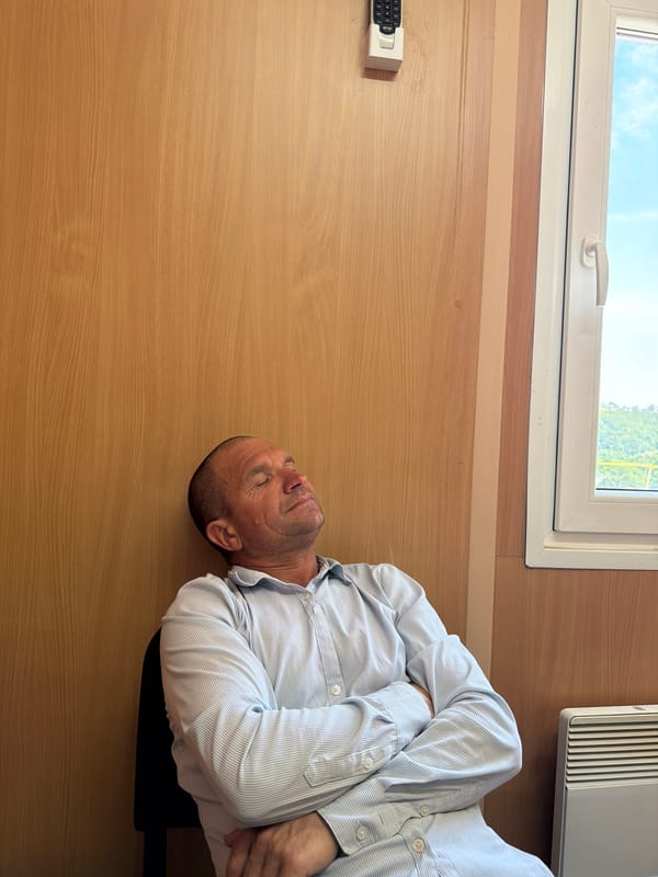 Person asleep in a wood-paneled room, others nearby