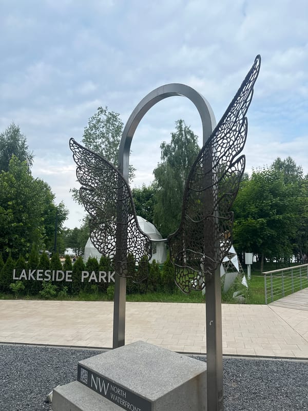 Visitor documents sculptures and wildlife during Minsk park afternoon stroll
