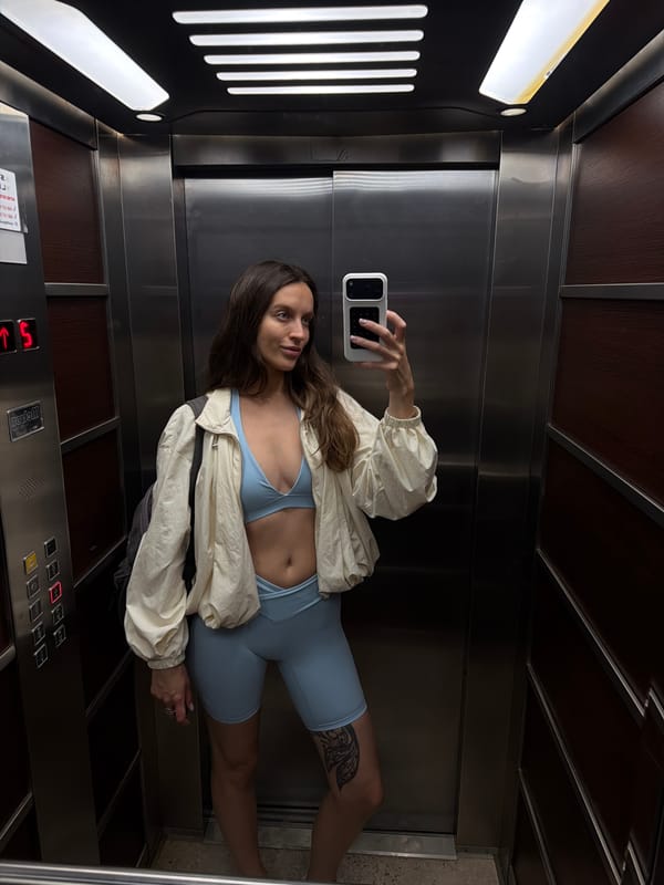 Woman Takes Selfie in Elevator Wearing Athletic Wear