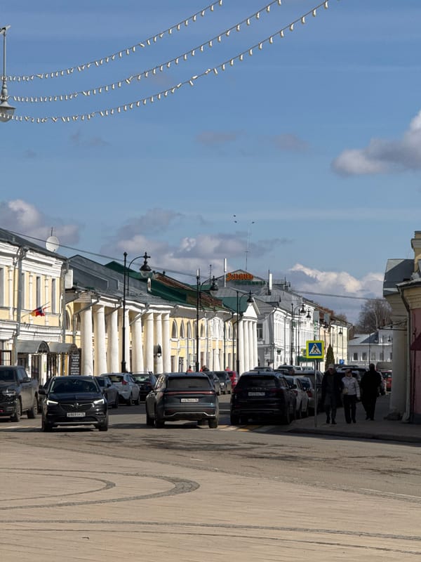 Woman photographs historic street scene in Novo-Nikol'skoe