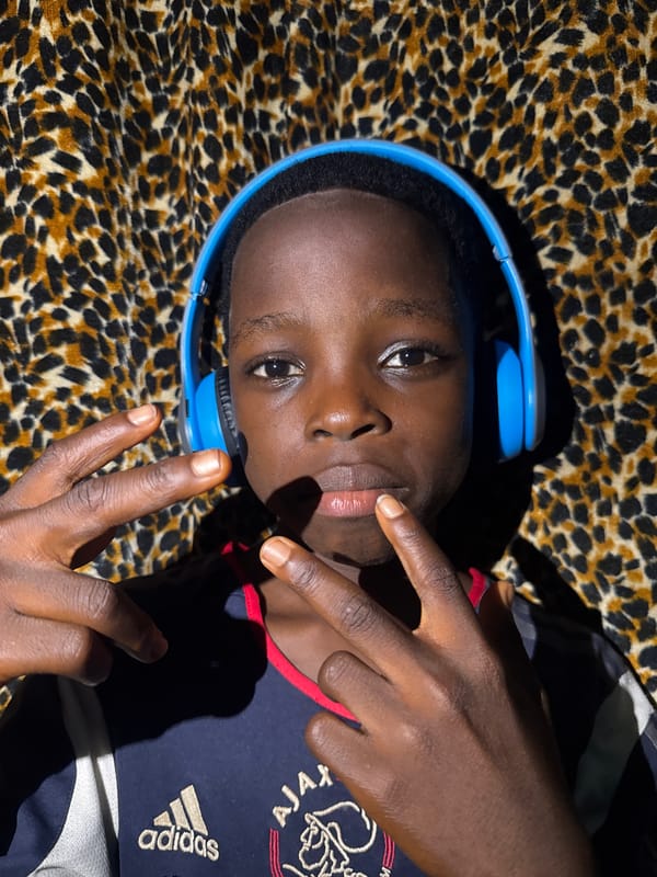 Person relaxes with headphones on leopard-print fabric in Onitsha