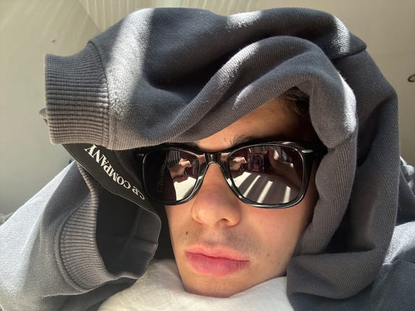 Person in sunglasses lies indoors in London