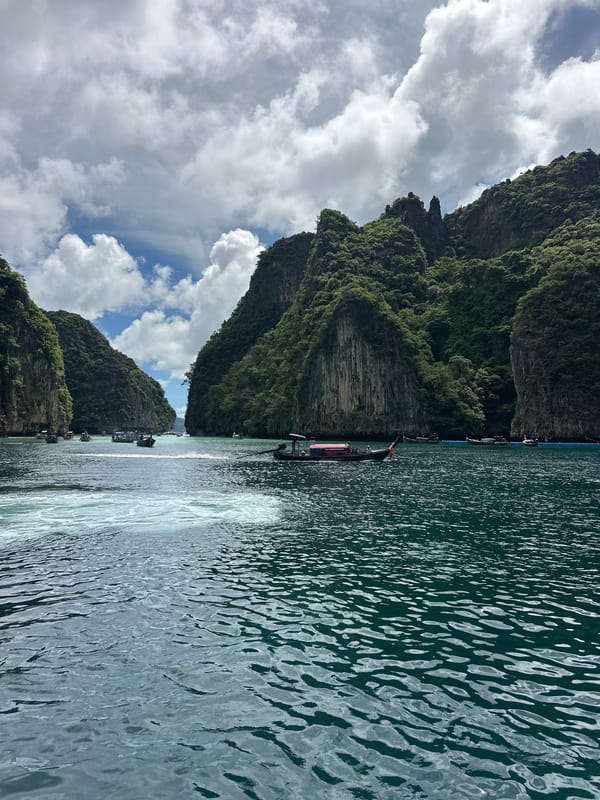 Speedboats navigate karst cliffs and turquoise waters off Ao Nang
