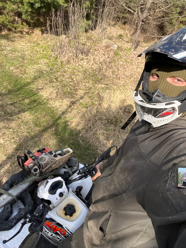 ATV riders with chainsaws traverse forest trails in Razdolye