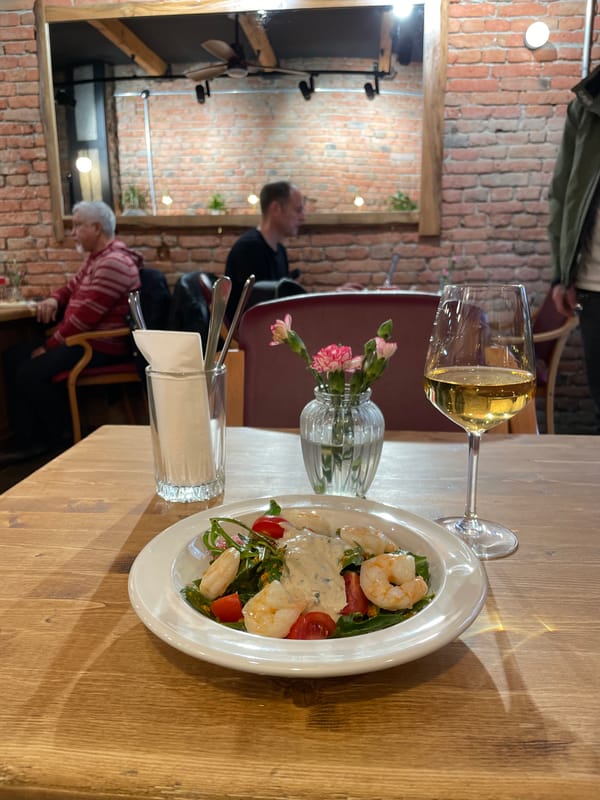 Diner enjoys shrimp salad and white wine in Tbilisi