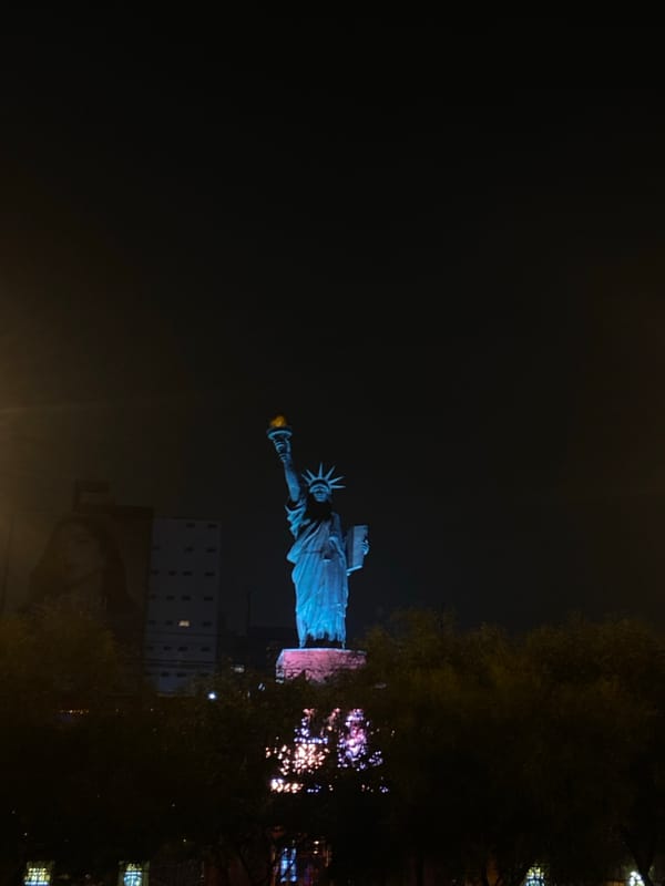 Statue of Liberty replica illuminated at night in Peru