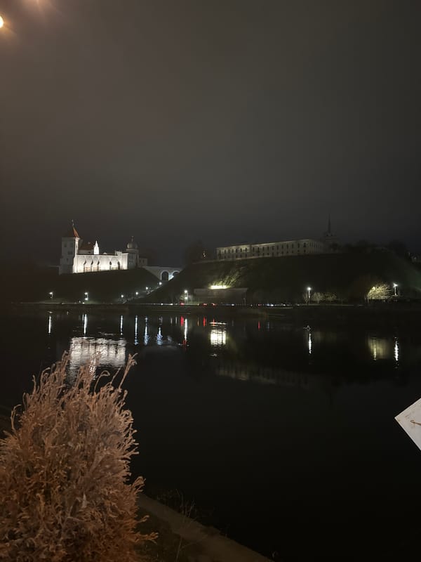 Illuminated Old Castle reflects on Neman River in Hrodna