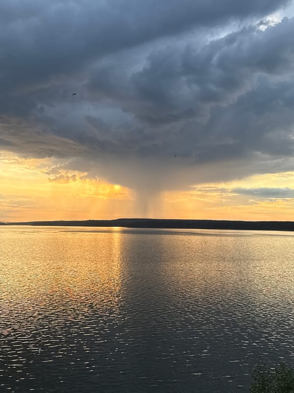 Storm clouds and golden light clash over Votkinsk waterfront at sunset