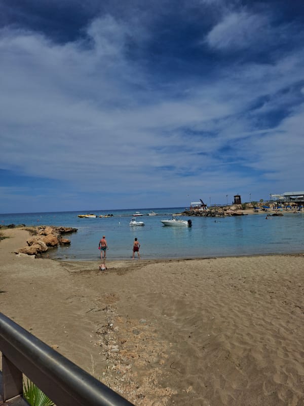 Two beachgoers wade in Fig Tree Bay waters, Cyprus