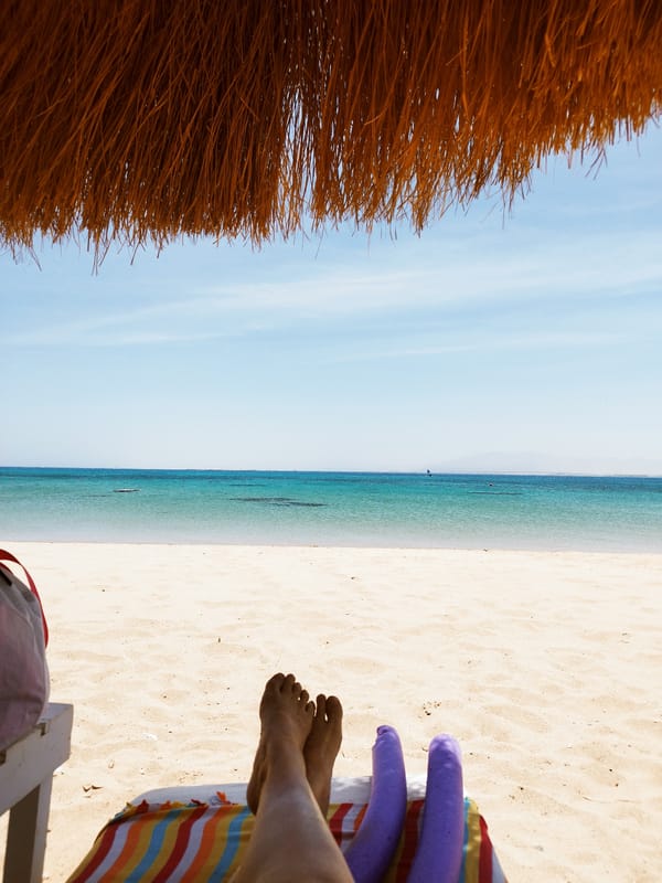 Beachgoer relaxes on lounge chair in Ras Abu Soma
