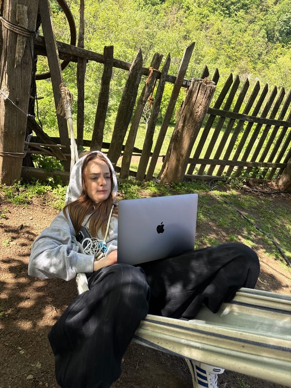 Woman works on laptop while relaxing in hammock outdoors
