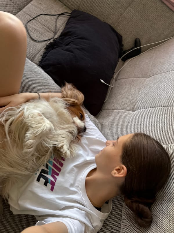 Woman relaxes with Cavalier King Charles Spaniel on Sofia couch