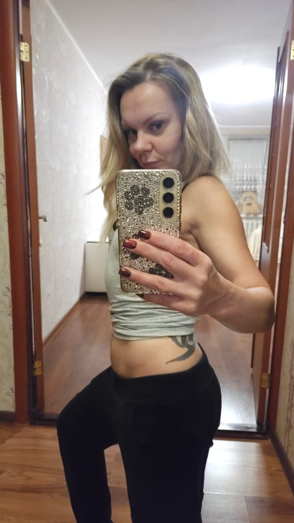 Woman takes mirror selfies in Sevastopol bedroom setting