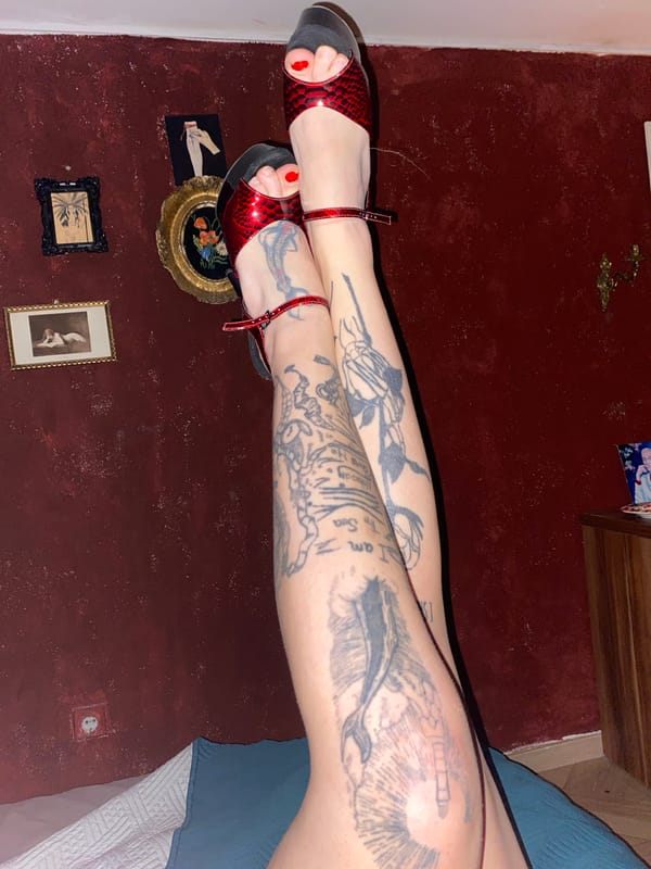 Tattooed woman photographed smoking indoors in Montenegro bedroom setting