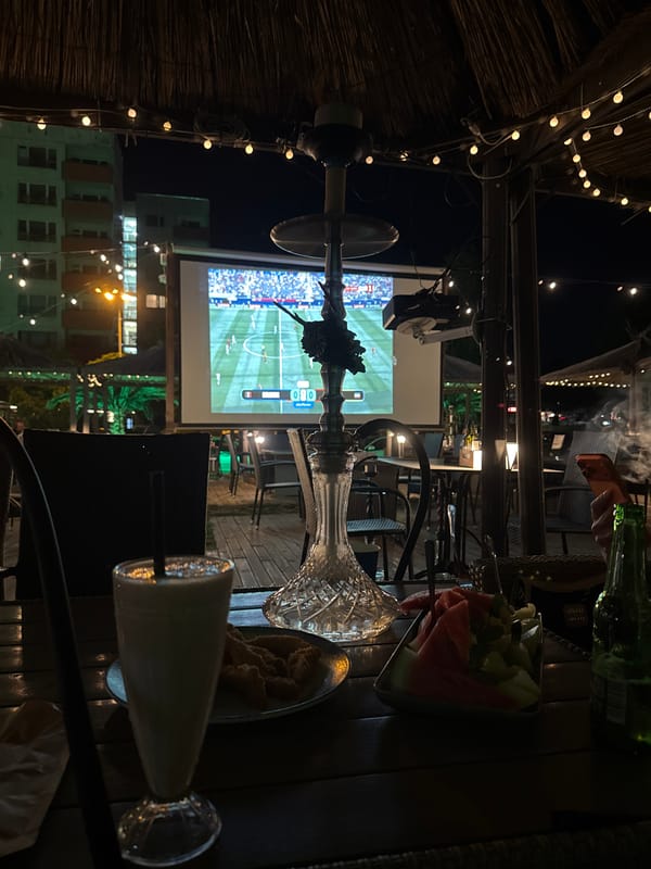 Late-night shisha lounge hangout with football, food, and friends