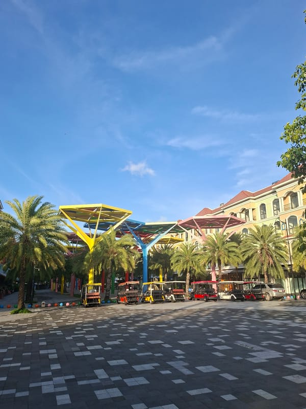 Colorful urban plaza with palms, sculptures, and decorative structures