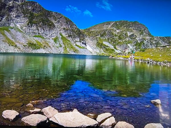 Mountain lake with clear water and rocks documented
