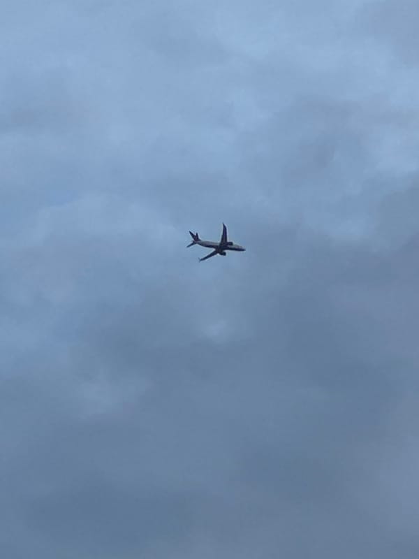 Passenger jet spotted overhead through cloudy skies over London