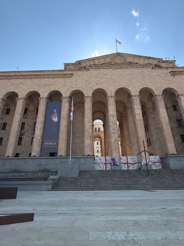 Person sits outside Georgian government building in Tbilisi