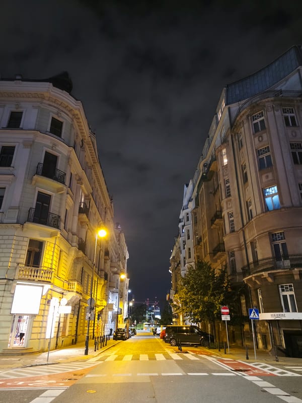 Late-night street scenes across central Warsaw's mixed architectural blocks